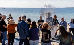 a group of people standing on a beach