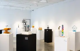 a room with white pedestals and sculptures
