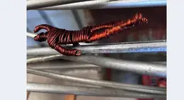 a wire sculpture of a person lying on metal rods