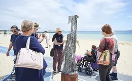 a group of people standing on a beach