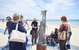 a group of people standing on a beach
