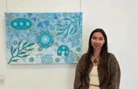 a woman standing in front of a painting