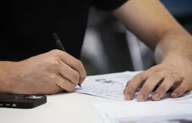 a person writing on a piece of paper