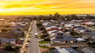 a street with cars and houses in the background
