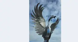 a metal bird statue with wings